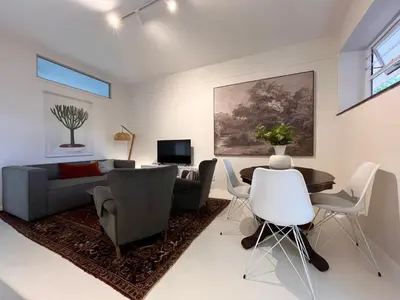 a living room with a couch and a table and chairs at Bosch & Bloom in Stellenbosch