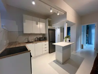 a kitchen with white cabinets and a black refrigerator at Bosch & Bloom in Stellenbosch