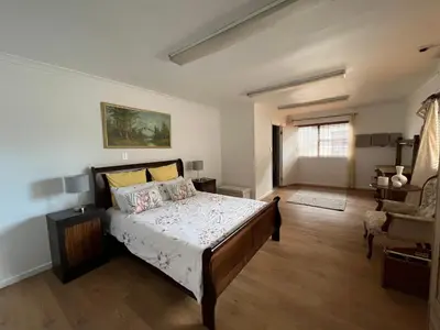 a bedroom with a bed and a chair in it at Central Somerset Stay in Somerset West