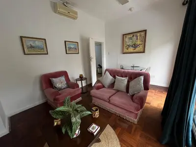 a living room with two red chairs and a table at Central Somerset Stay in Somerset West