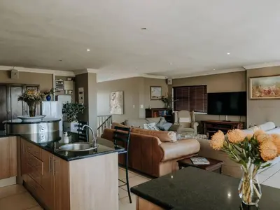 a kitchen and a living room with a couch at Shores Keep - Self Catering Home in Hermanus
