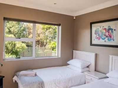 two beds in a room with two windows at Shores Keep - Self Catering Home in Hermanus