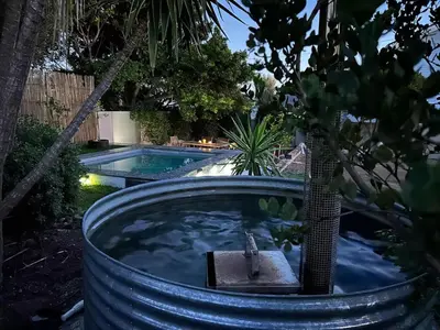 a jacuzzi tub in a yard with a pool at Shores Keep - Self Catering Home in Hermanus