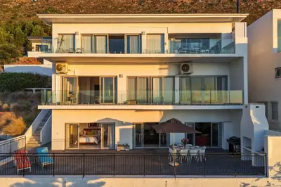a house with a balcony with tables and chairs at Suikerbossie 52 in Cape Town