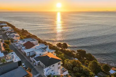 an aerial view of a house and the ocean at sunset at Suikerbossie 52 in Cape Town