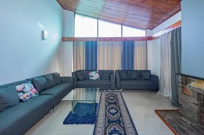 a living room with a couch and a glass table at Wilcuma Lodge in Plattekloof