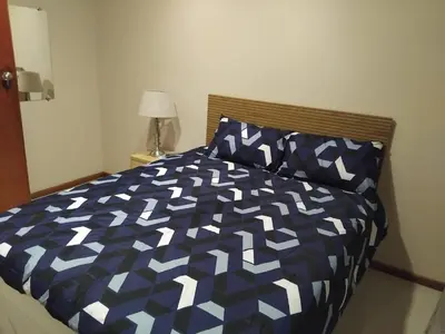 a bed with a blue and white comforter in a bedroom at Wilcuma Lodge in Plattekloof