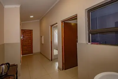 a bathroom with a toilet and a window and a door at Wilcuma Lodge in Plattekloof