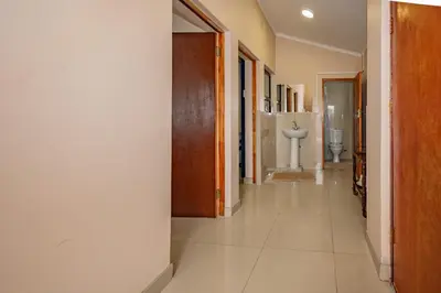 a hallway leading to a bathroom with a sink at Wilcuma Lodge in Plattekloof