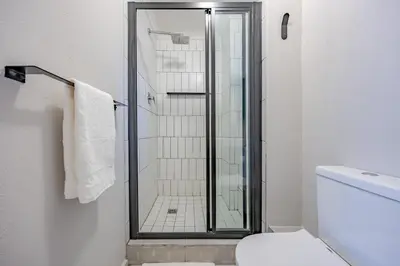 a bathroom with a glass shower with a toilet at Modern 2 bed, 2 bath, 14B- Blouberg in Bloubergstrand