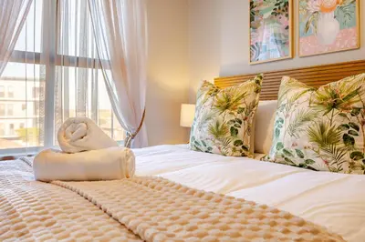 a bed with a towel on it with a window at Modern 2 bed, 2 bath, 14B- Blouberg in Bloubergstrand