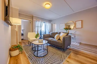 a living room with a couch and a table at Modern 2 bed, 2 bath, 14B- Blouberg in Bloubergstrand