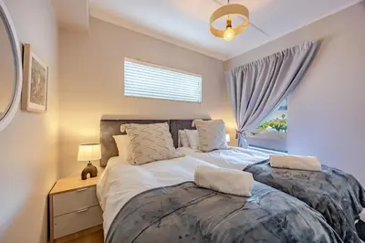 a bedroom with a large bed with a window at Modern 2 bed, 2 bath, 14B- Blouberg in Bloubergstrand