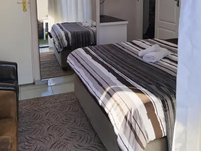 a bedroom with two beds with towels on them at Eneco Lodge in Cape Town