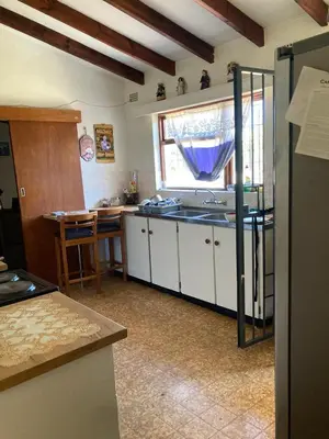 a kitchen with white cabinets and a sink and a window at Halibut Suite in Strand
