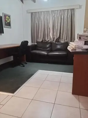 a living room with a black couch and a piano at Halibut Suite in Strand