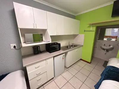 a small kitchen with a sink and a microwave at M&D Guest House in Bellville