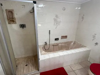 a bath tub in a bathroom with a shower at M&D Guest House in Bellville