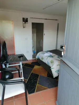 a room with a bed and a desk and a bed sidx sidx sidx at 72 Hamilton the trout lodge in Goodwood