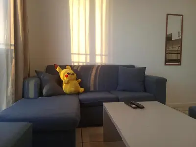 a stuffed animal sitting on a couch in a living room at Klipkop Self-catering Haven in Cravenby