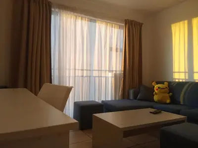 a living room with a blue couch in front of a window at Klipkop Self-catering Haven in Cravenby