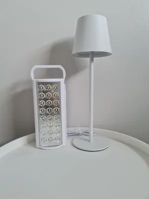 a remote control sitting on a table next to a lamp at Spring Tide Beach Flat Child Petfriendly Hot Tub in Bloubergstrand