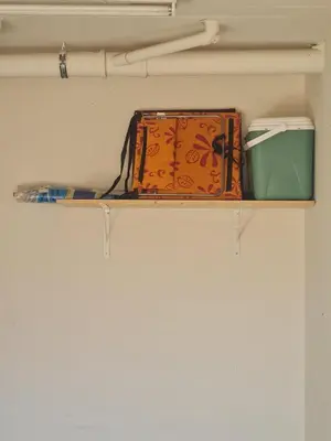 a shelf with a suitcase and other items on it at Spring Tide Beach Flat Child Petfriendly Hot Tub in Bloubergstrand