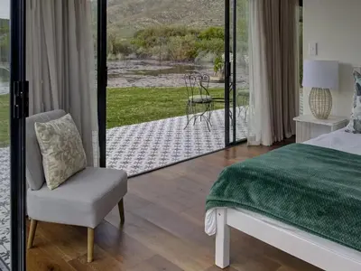 a bedroom with a bed and a chair and a patio at Lily Pond in Worcester