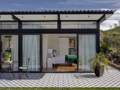 a bedroom in a glass house with a bed at Lily Pond in Worcester