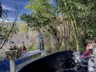 a table with a bottle of beer and a basket of flowers at Lily Pond in Worcester