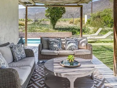 a patio with couches and a table and a pool at Vineyard House in Worcester