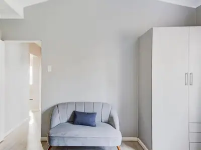 a white couch with a blue pillow in a room at Vineyard House in Worcester