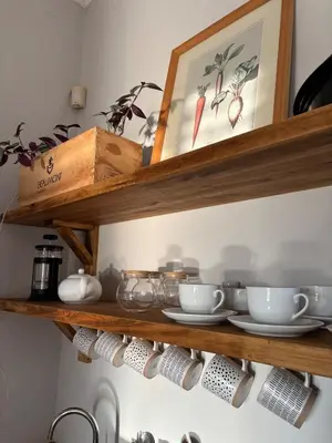 a kitchen shelf with bowls and dishes on it at Libertas House, Cheverells Farm in Grabouw