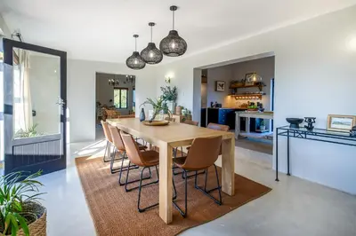 a kitchen and dining room with a wooden table and chairs at Libertas House, Cheverells Farm in Grabouw