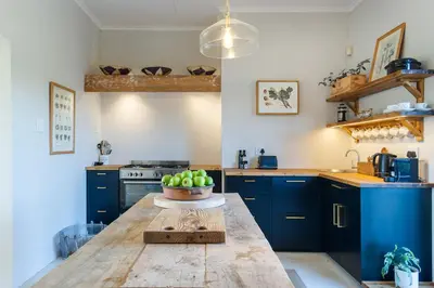 a kitchen with a table with a bowl of apples on it at Libertas House, Cheverells Farm in Grabouw