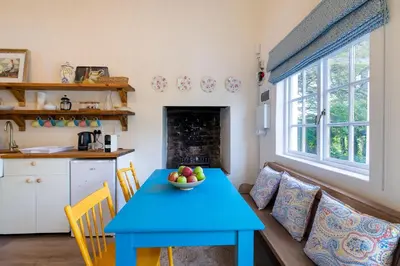 a living room with a blue table and a couch at Bramley Cottage, Cheverells Farm in Grabouw