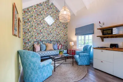 a living room with a couch and two chairs at Bramley Cottage, Cheverells Farm in Grabouw