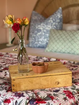a vase with flowers and a bowl on a wooden table at Cripps Cottage, Cheverells Farm in Ouda Brug