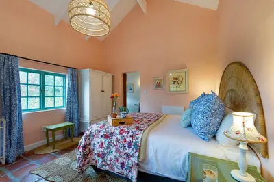a bedroom with a large bed and a window at Cripps Cottage, Cheverells Farm in Ouda Brug