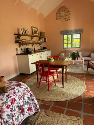 a living room with a table and a kitchen at Cripps Cottage, Cheverells Farm in Ouda Brug