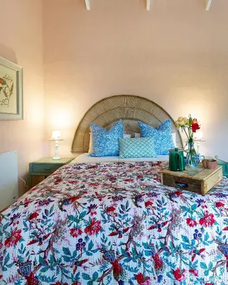 a bedroom with a large bed with a colorful bedspread at Cripps Cottage, Cheverells Farm in Ouda Brug