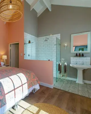 a bedroom with a bed and a bathroom with a sink at Crabapple Cottage, Cheverells Farm in Ouda Brug