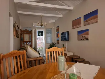 a dining room with a wooden table and chairs at Mukuru Okunene in Strand