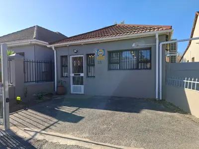 a white house with a gate and a driveway at Mukuru Okunene in Strand