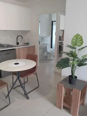 a kitchen with a table and a potted plant at Joseph's Place Sandown CAPE TOWN in Cape Town