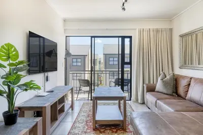 a living room with a couch and a table at Joseph's Place Sandown CAPE TOWN in Cape Town