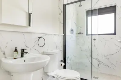 a white bathroom with a toilet and a sink at Joseph's Place Sandown CAPE TOWN in Cape Town
