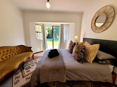 a bedroom with a bed and a mirror and a window at River Front in Stellenbosch