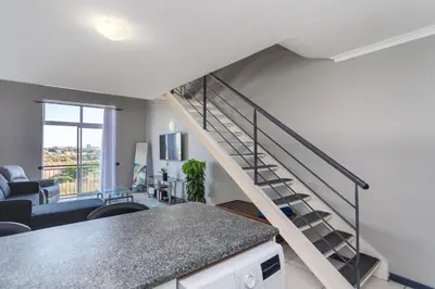 a living room with a staircase in a house at Century on Lake B31 by CTHA in Cape Town