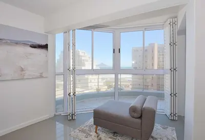 a living room with a couch and a large window at Ocean View B401 by CTHA in Bloubergstrand